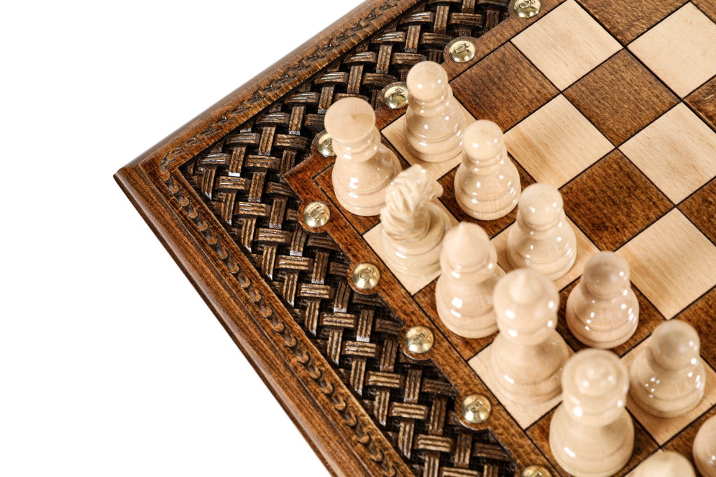 Light hand-carved chess pieces on the wooden chess board beside the woven braid border