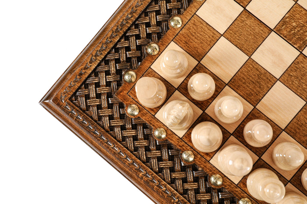 Close view of the braid carving, bronze studs and light chess pieces at the board edge