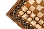 Close view of the braid carving, bronze studs and light chess pieces at the board edge