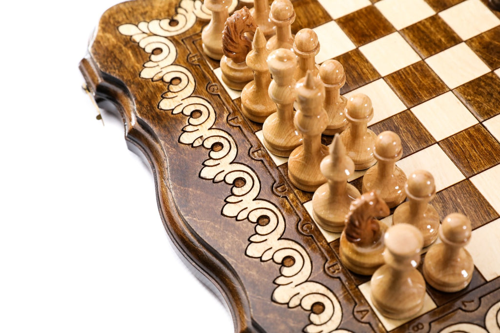 Light wooden chess pieces beside the two-tone scroll ornament of the scalloped frame