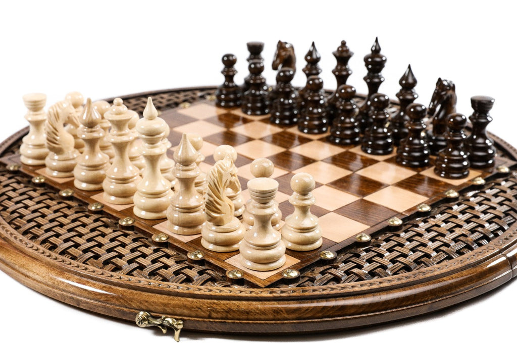 circular chess board with carved design and bronze accents