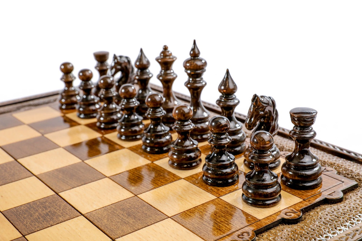 Dark hand-carved chess pieces on the beech and walnut checkered board