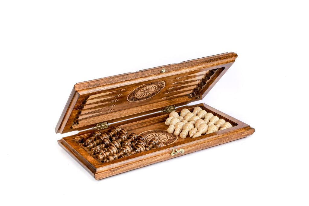 Chess backgammon set half open with the hand-carved pieces stored on the backgammon field