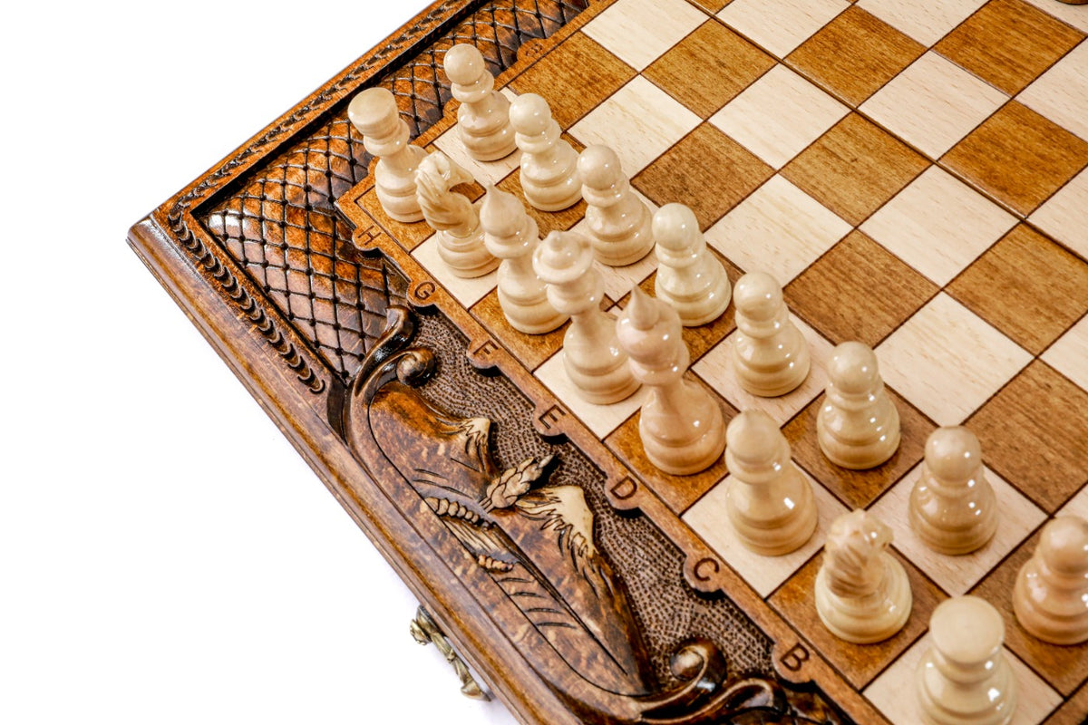 Light hand-carved chess pieces beside the carved Mount Ararat on the board frame