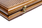 Edge of the closed walnut board with the cast-bronze clasp and lattice lid