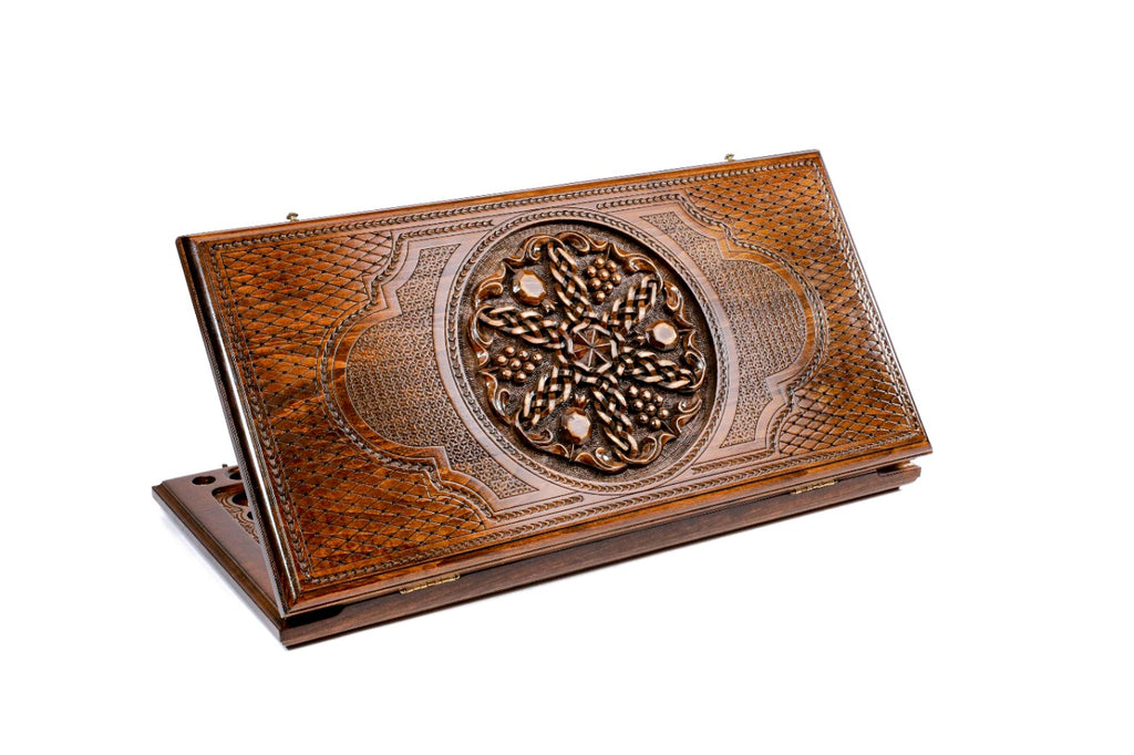 A frontal shot of the closed backgammon board by Hrachya Ohanyan showing the detailed pomegranate and grape cluster carvings.