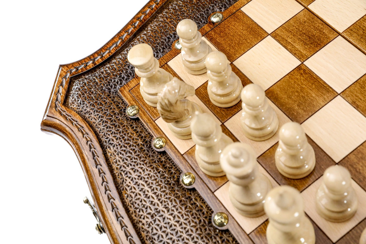 Light hand-carved chess pieces beside the textured contour frame of the wooden chess board