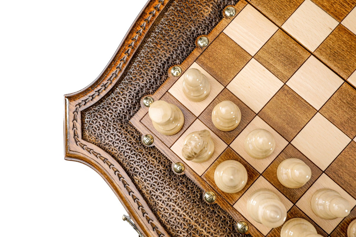 Close view of the curved carved edge, bronze studs and light chess pieces