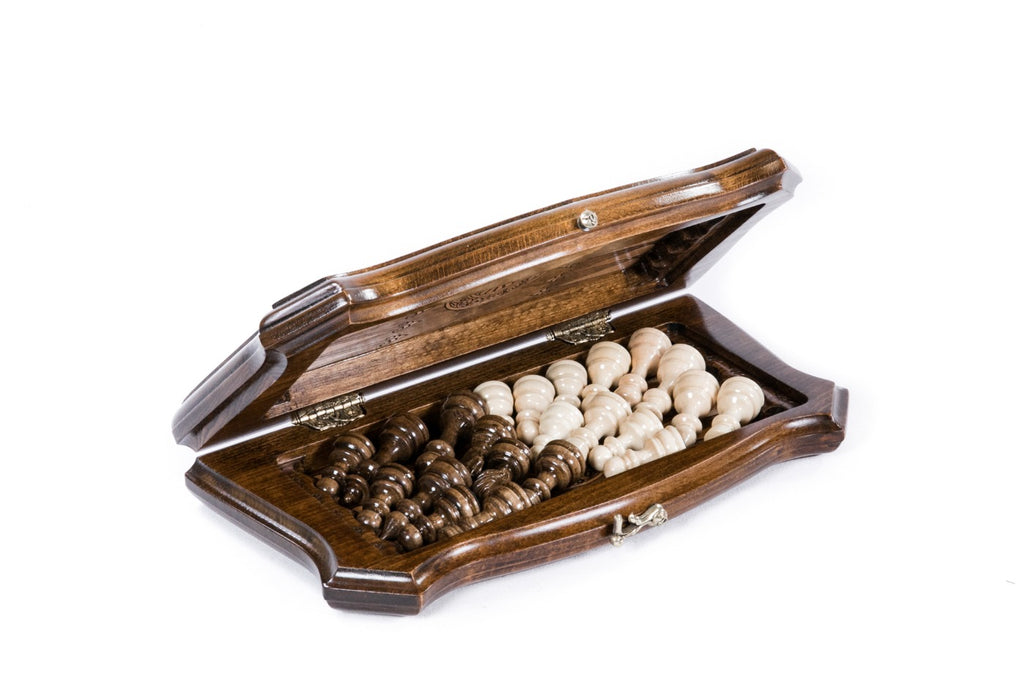 Chess backgammon set half open with the hand-carved pieces stored on the backgammon field