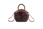 Round wooden handbag in dark plum — detail view