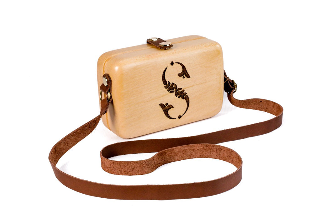 Engraved wooden bag with leather strap — side view