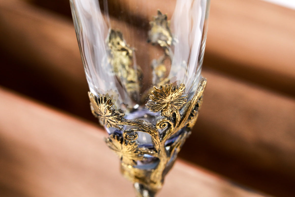 Bronze and glass cup with grape-textured bronze support — close-up