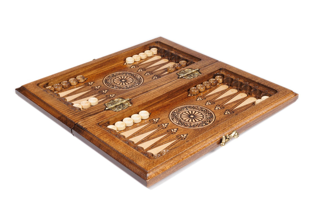 Travel chess backgammon set opened to the carved backgammon field with wheel ornaments and checkers