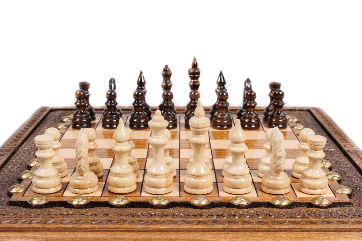 Hand-carved chess pieces in beech and walnut lined up on the portable chess board