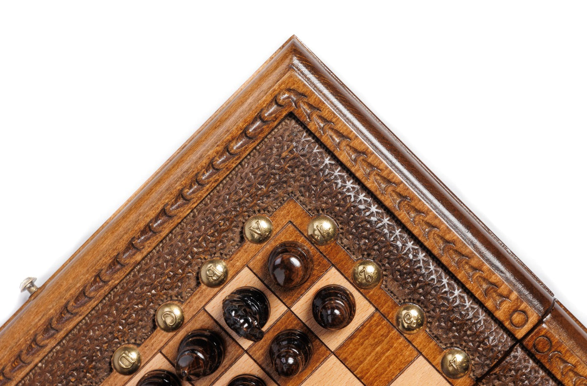 Corner of the carved wooden frame with dark chess pieces and bronze studs