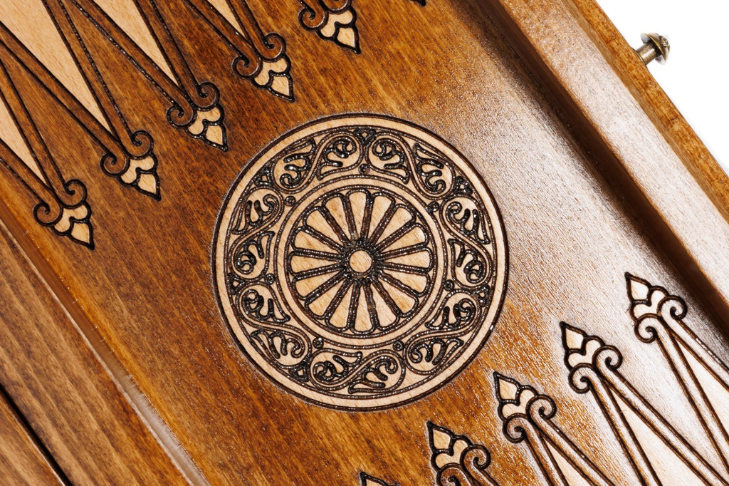 Close-up of the carved wheel ornament between the backgammon points