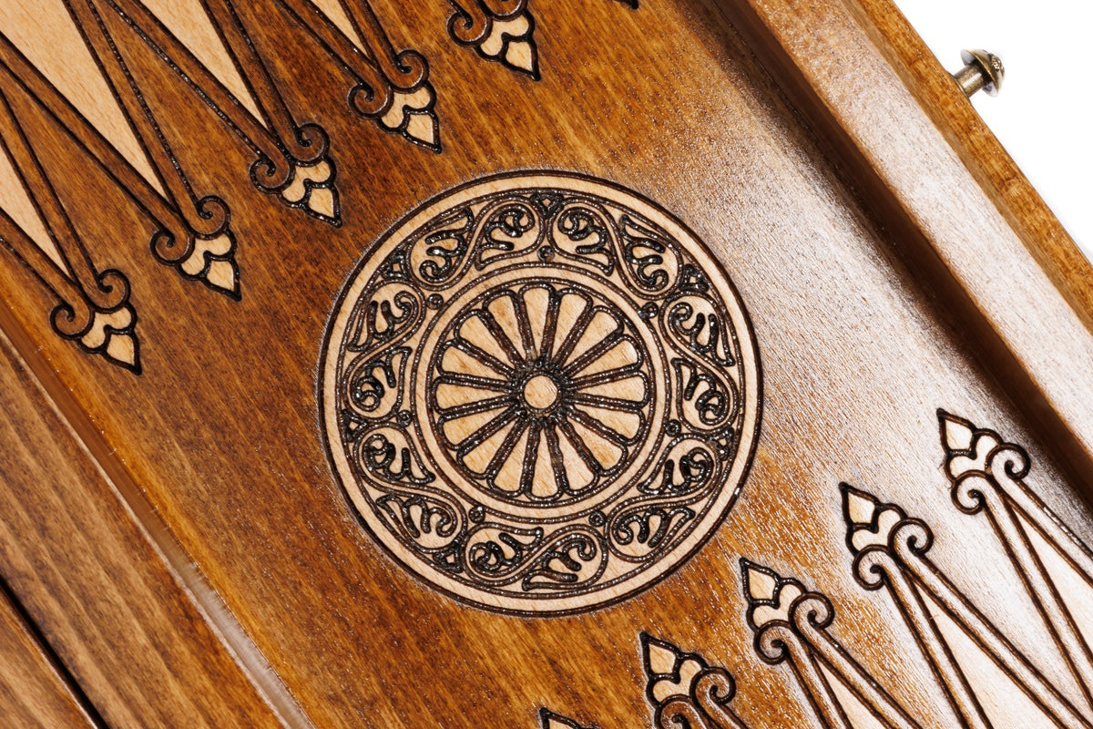 Close-up of the carved wheel ornament between the backgammon points