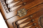 Ornate cast-bronze hinge on the carved backgammon field of the travel set
