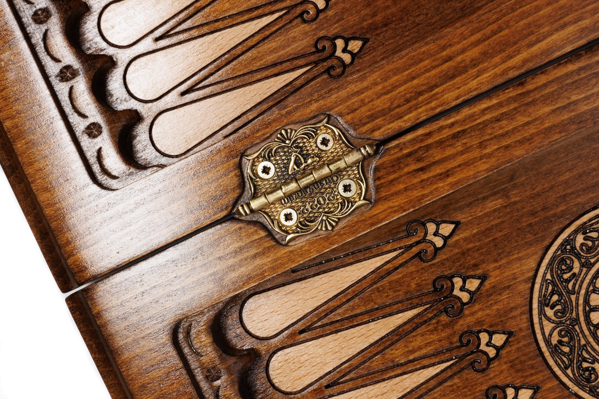 Ornate cast-bronze hinge on the carved backgammon field of the travel set