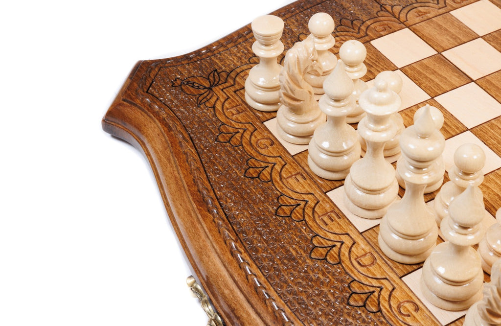 Light hand-carved chess pieces beside the carved scroll ornament of the contour frame