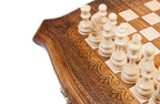 Light hand-carved chess pieces beside the carved scroll ornament of the contour frame