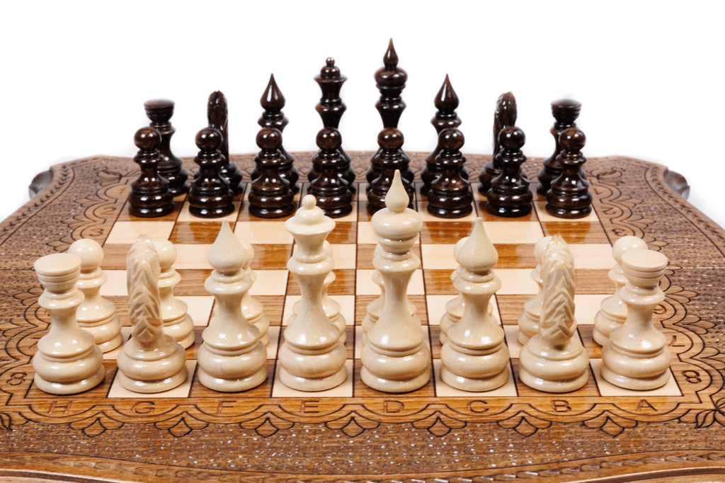 Front view of the travel chess set with hand-carved pieces and carved coordinates on the curved board