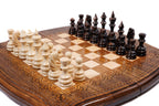 Hand-carved chess board with contour outline and leaf-scroll ornament, carved pieces in position, close angle