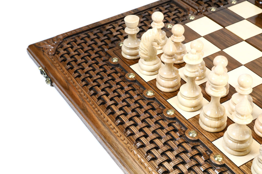 Light hand-carved chess pieces beside the open braid frame of the walnut epoxy chess board