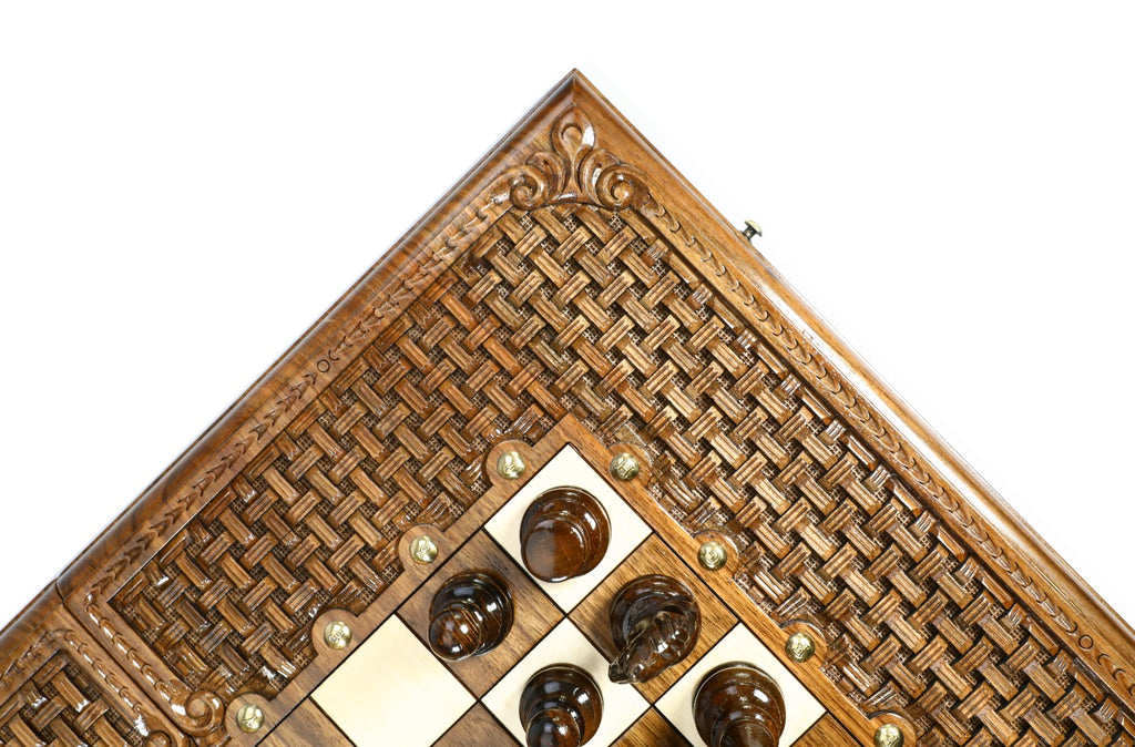 Corner of the walnut board with open braid frame and dark chess pieces on the epoxy field