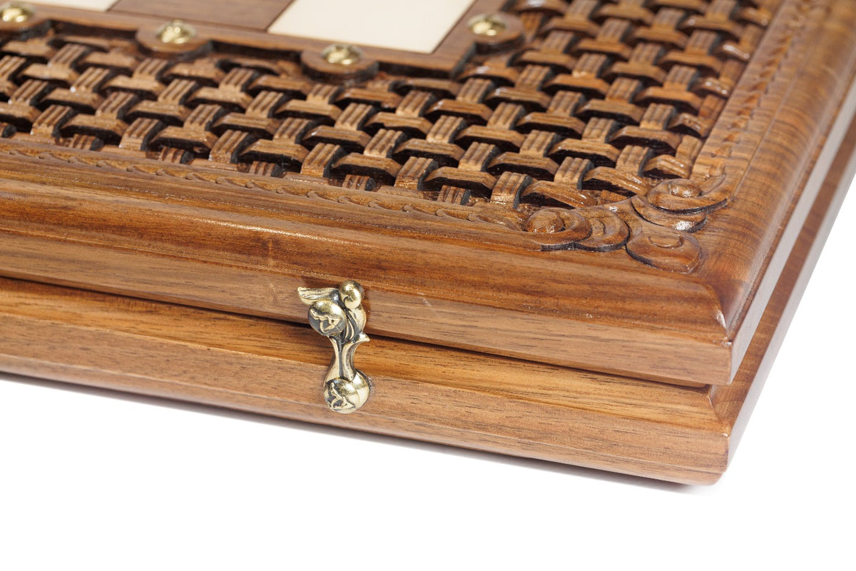 Close-up of the open-cut braid ornament and cast-bronze clasp on the walnut chess set