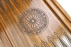 Close-up of the carved wheel ornament under clear epoxy on the walnut backgammon field