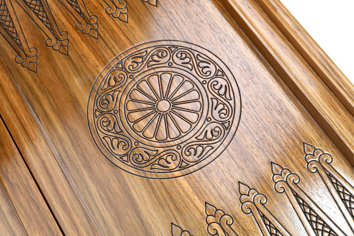 Close-up of the carved wheel ornament under clear epoxy on the walnut backgammon field