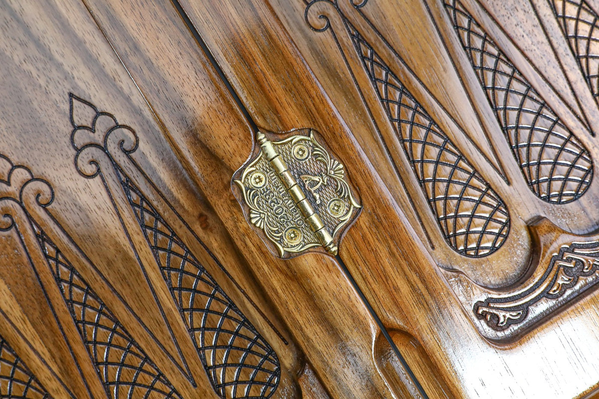 Ornate cast-bronze hinge and carved lattice points on the resin-finished walnut backgammon field