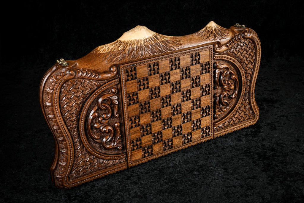 Wooden chessboard with intricate carvings on a black background