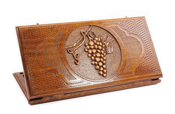 A frontal shot of the closed Grape Cluster classic backgammon board showing the detailed vine and fruit relief carving.