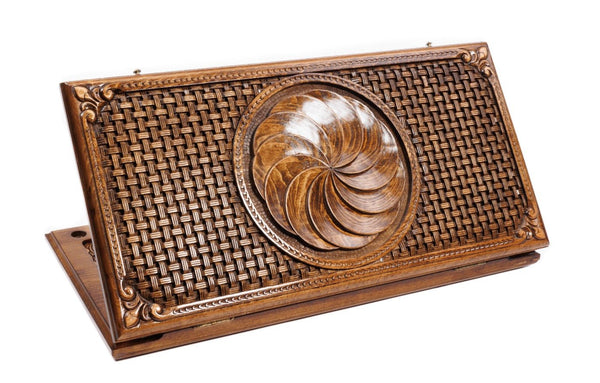 A top-down view of the closed wooden backgammon board featuring the carved Eternity wheel and intricate braid borders.