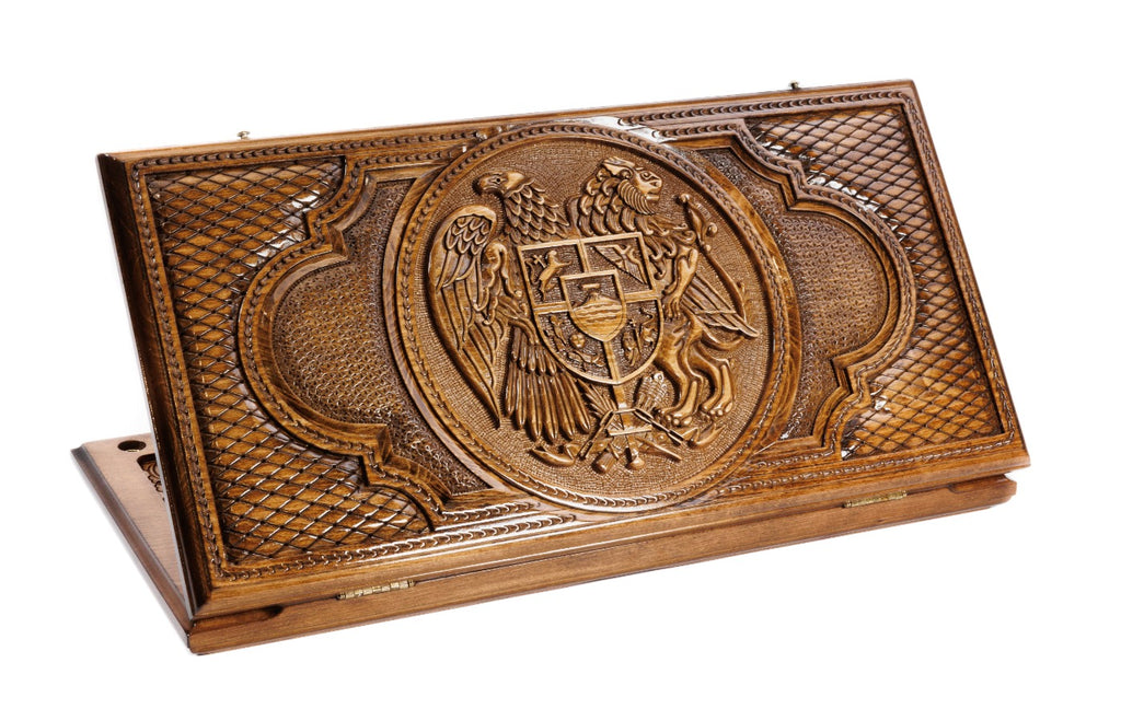 A split view of the two-sided backgammon board showing the Armenian national emblem and the Russian double-headed eagle carvings.