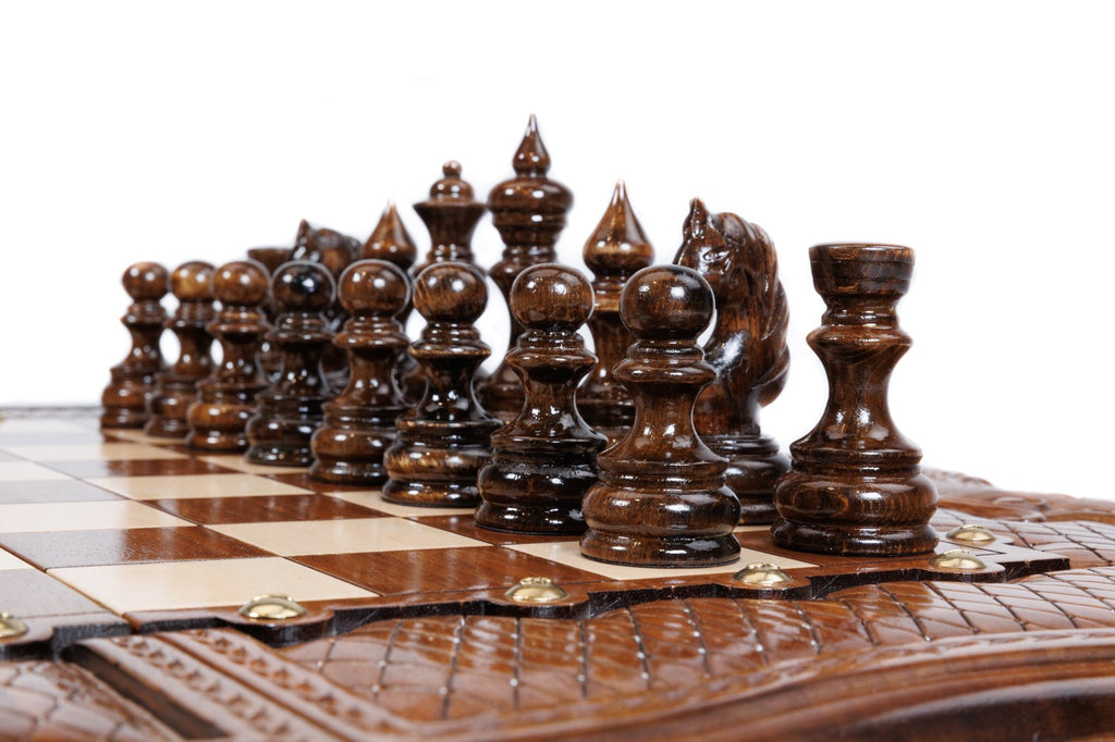 Dark hand-carved chess pieces on the walnut and hornbeam squares of the large chess board