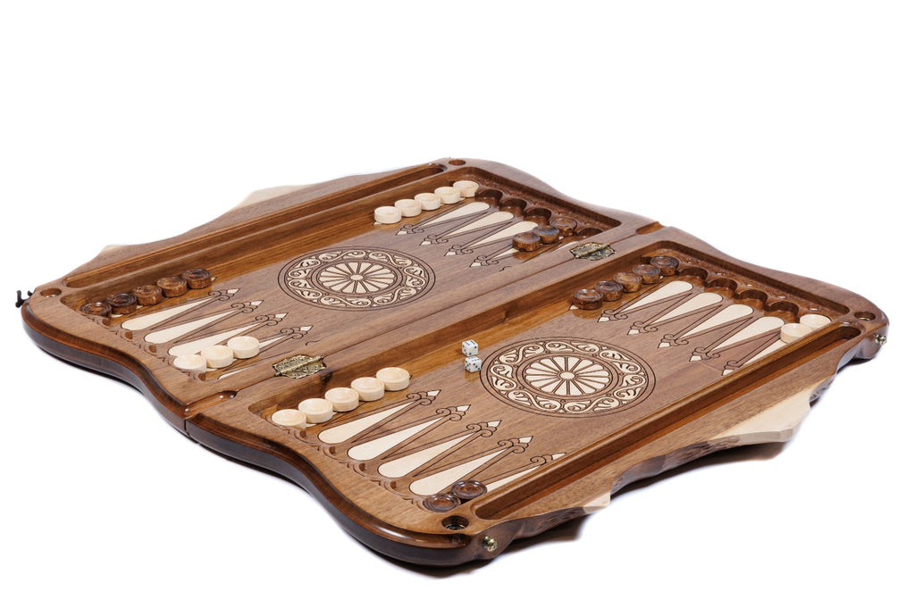 Walnut chess and backgammon set opened to the carved backgammon field with wheel ornaments and checkers