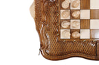 Light hand-carved chess pieces beside the carved braid border and scrollwork of the walnut board