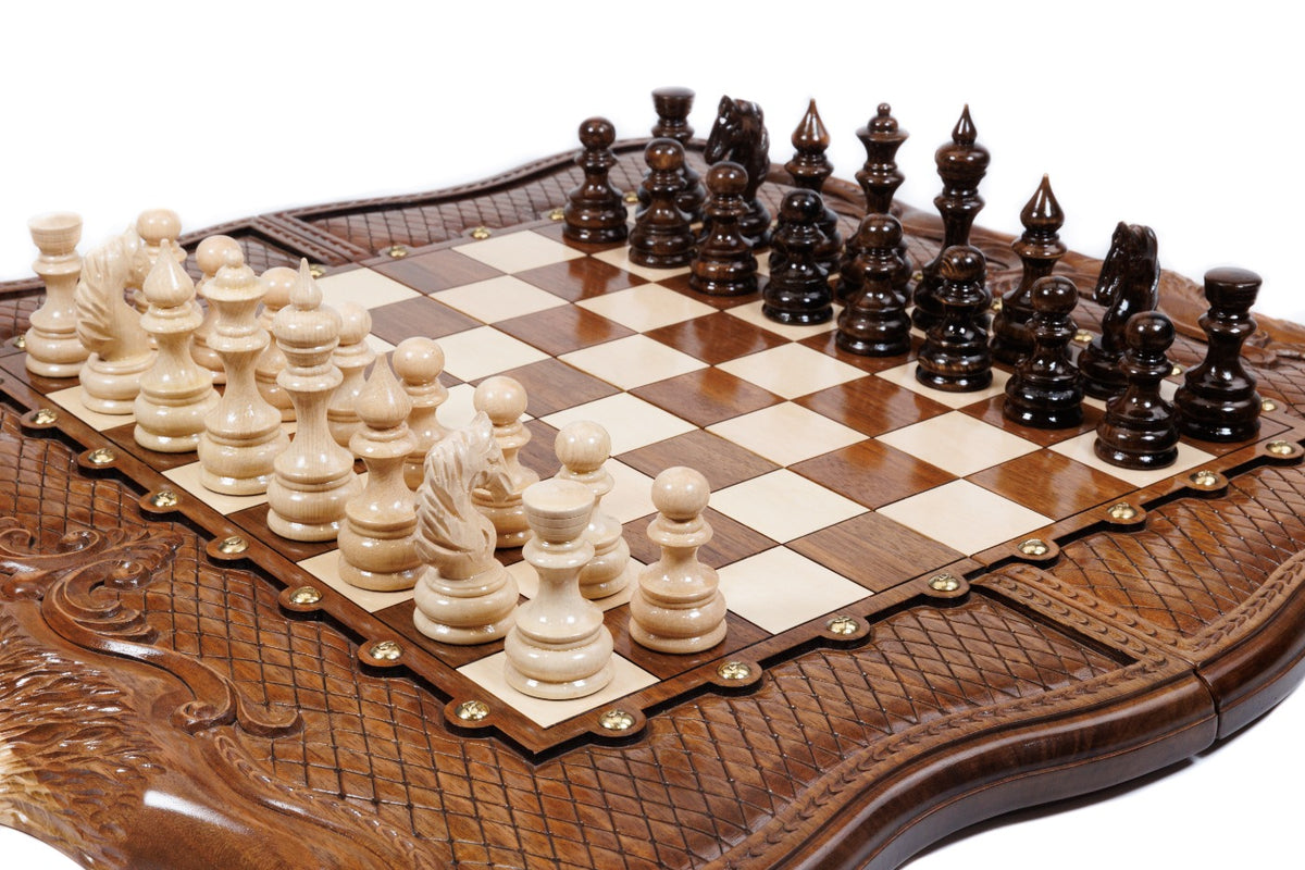 Hand-carved walnut chess board with braid border, bronze studs and carved pieces, close angle