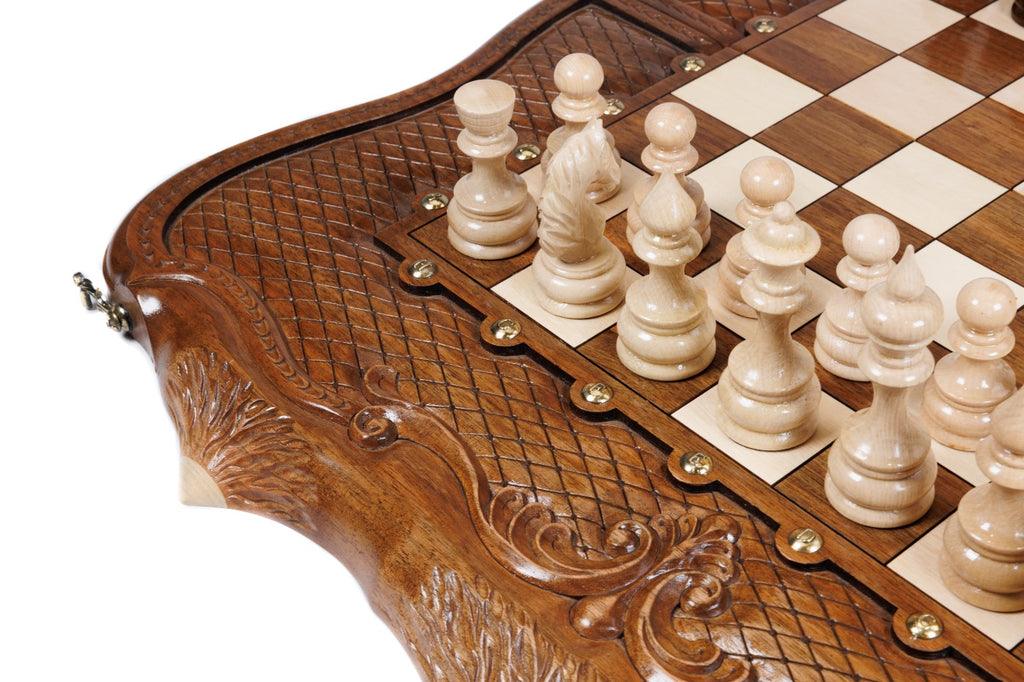 Close view of the deep scrollwork carving and light chess pieces on the walnut chess set