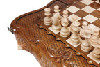 Close view of the deep scrollwork carving and light chess pieces on the walnut chess set