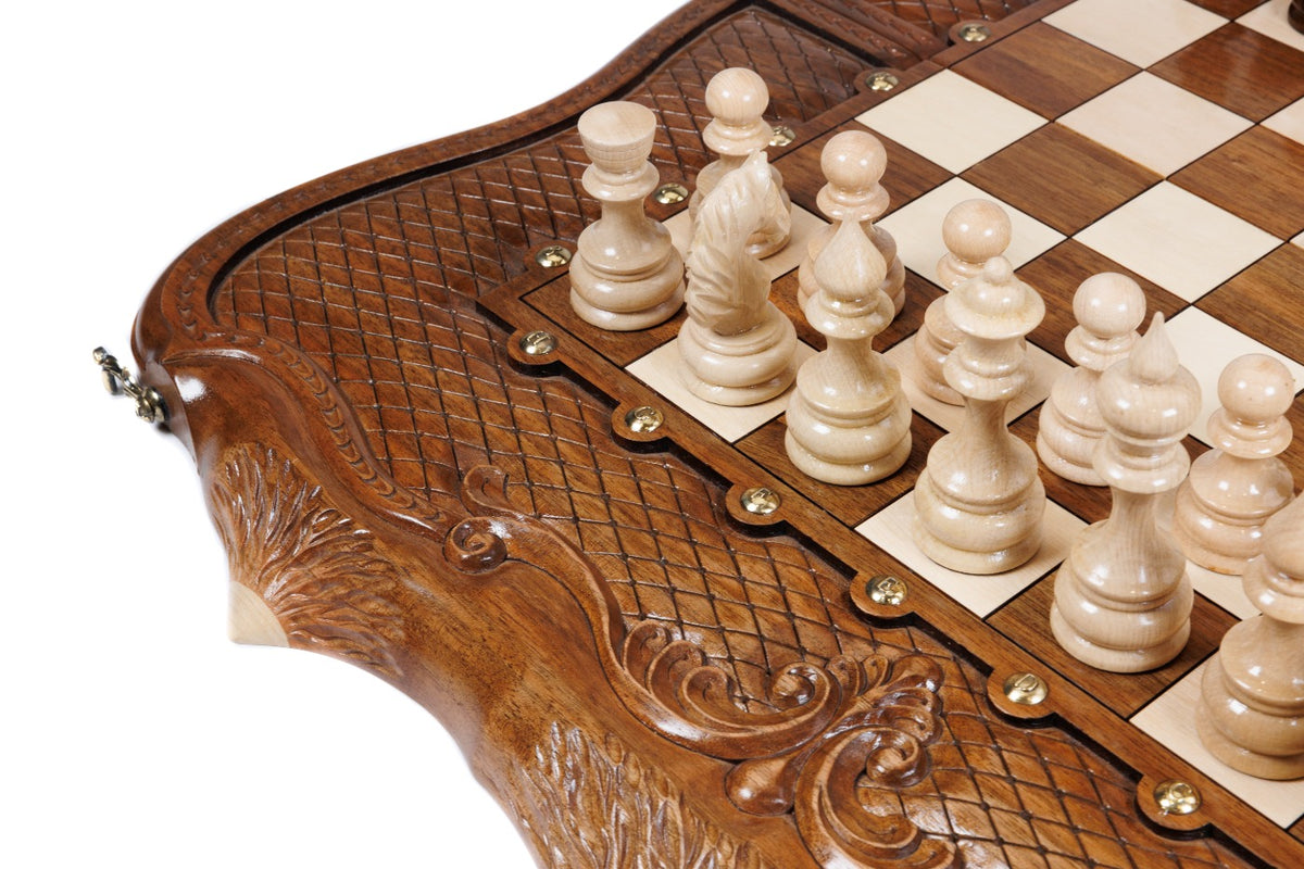 Close view of the deep scrollwork carving and light chess pieces on the walnut chess set