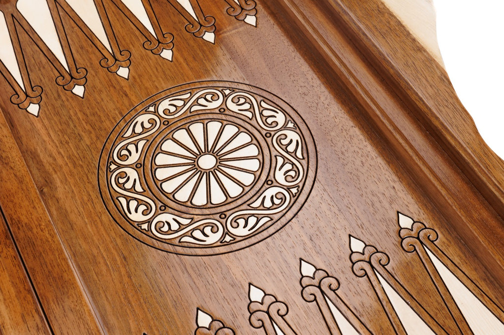 Close-up of the carved wheel ornament and carved points on the walnut backgammon field