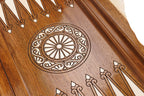 Close-up of the carved wheel ornament and carved points on the walnut backgammon field