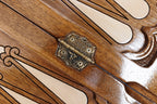 Ornate cast-bronze hinge on the carved walnut backgammon field