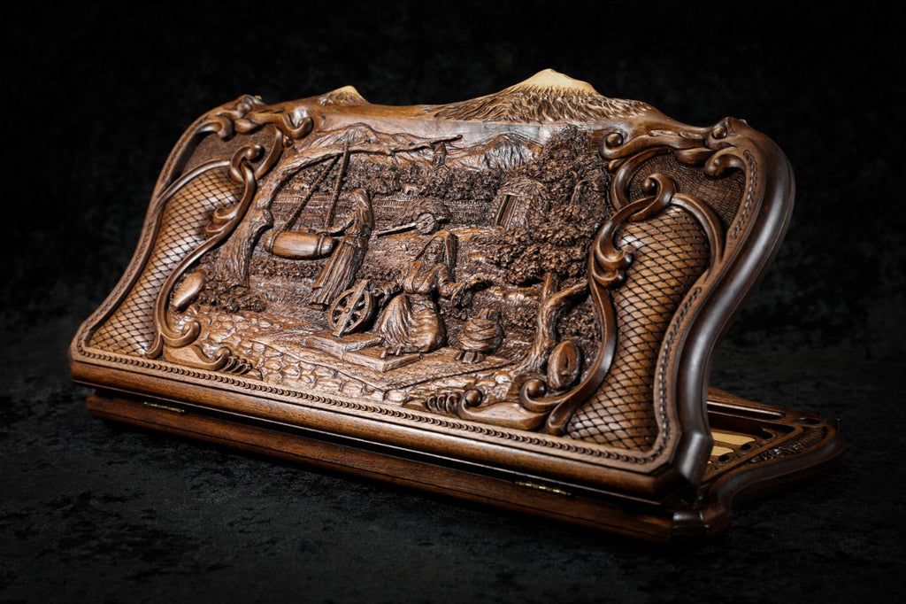 Village scene backgammon set closed, front view of the carved scene in its rococo scroll frame