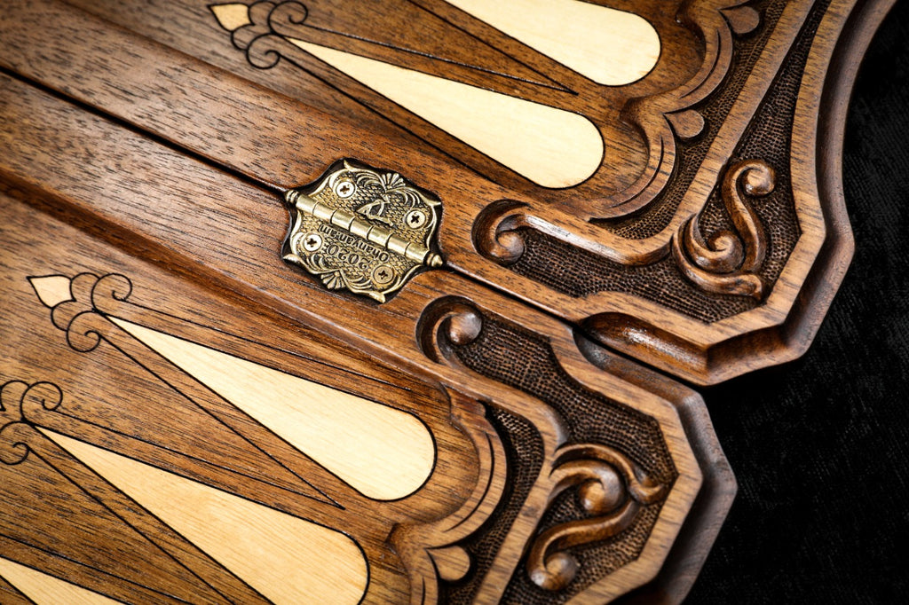 Hornbeam-inlaid points and the stamped cast-bronze hinge on the open walnut board