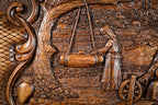 Woman at the spinning wheel beside the house, carved in deep relief, close-up